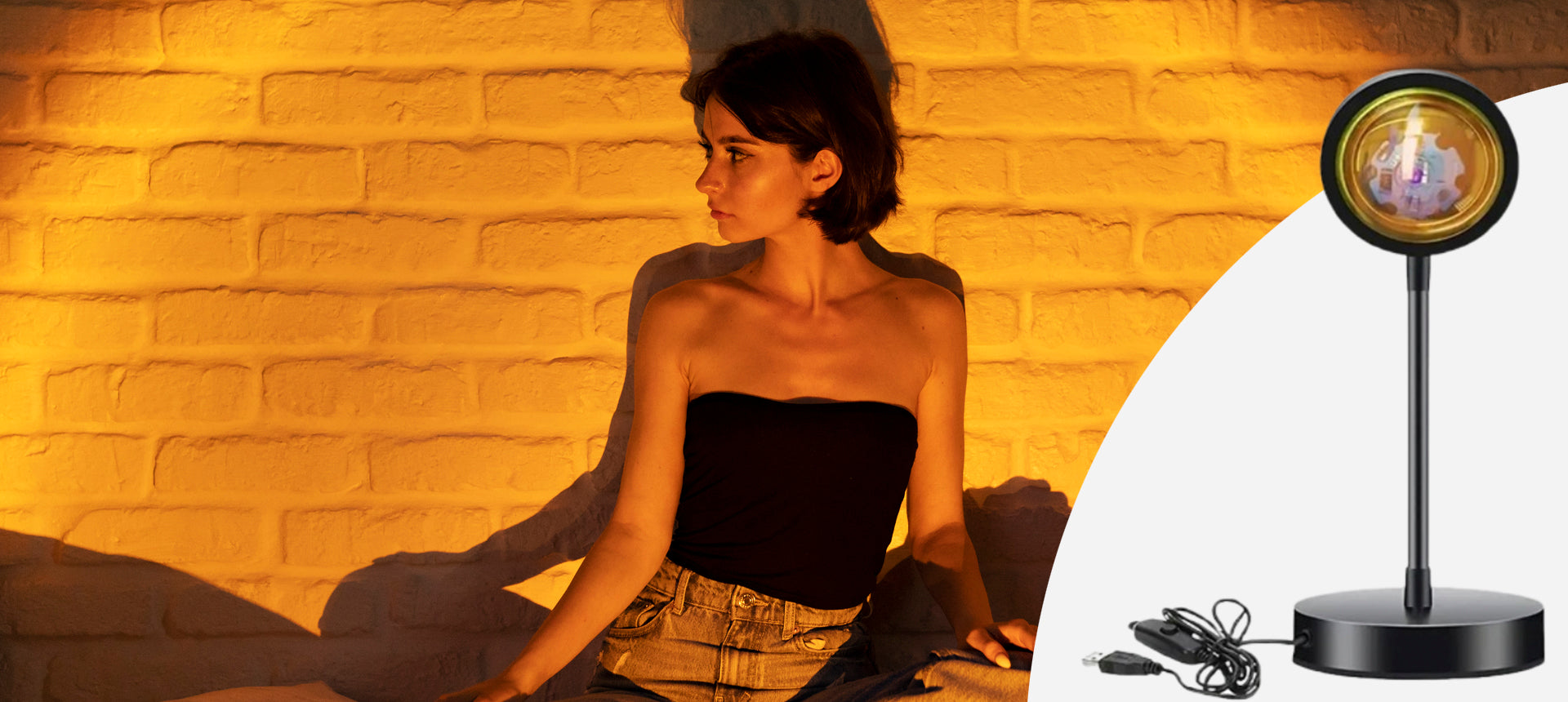 Woman sitting in a warm-lit room with a black lamp emitting heat.